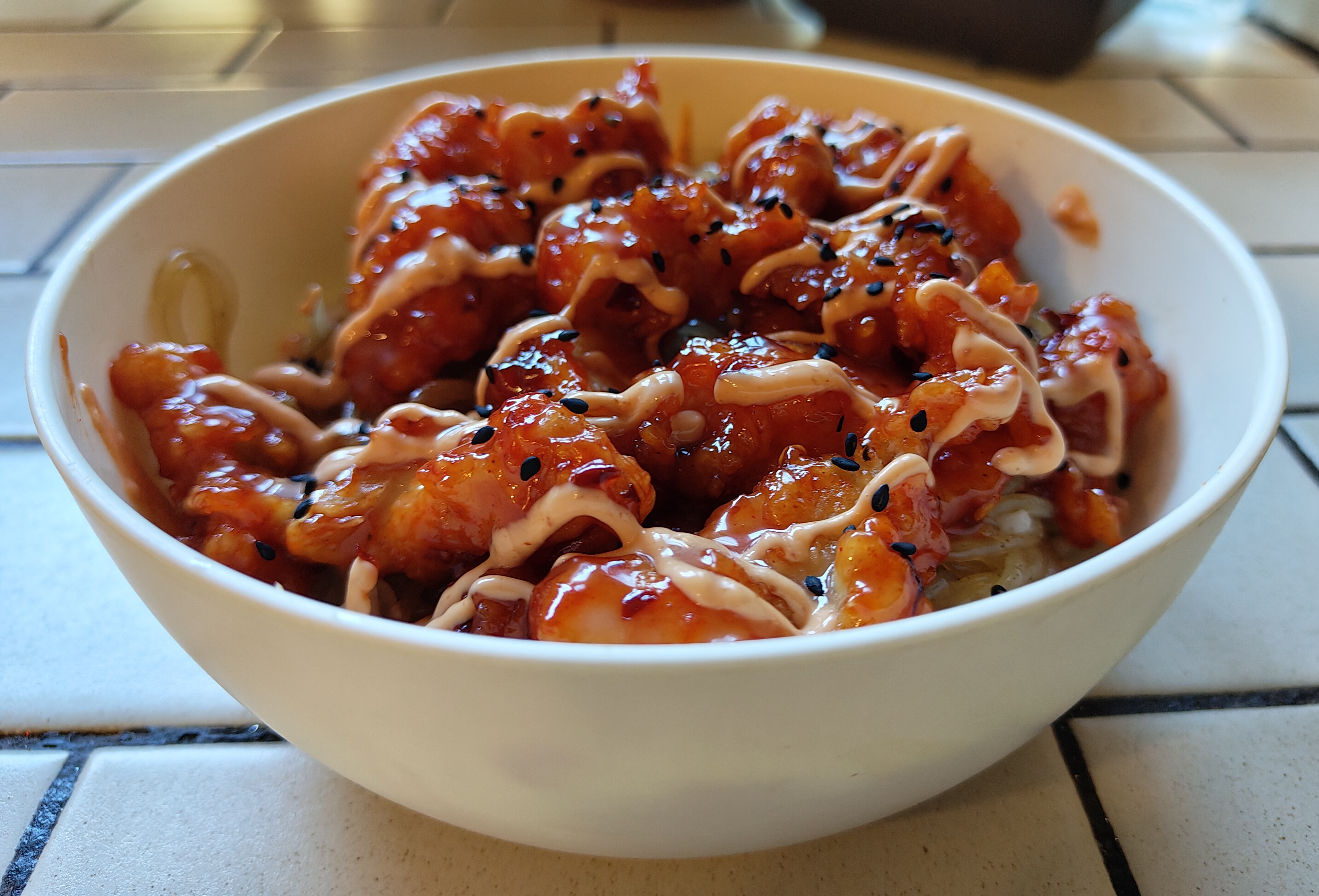 Bowl of CupBop where the chicken is glazed with spicy red sauce